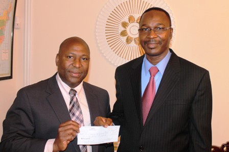 Guy LINGANI, président de l'ABURWA remettant le chèque à Seydou Bouda.