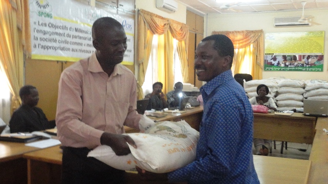 Le représentant du SP/CNLS-IST, Joachim Ouédraogo, remettant symbolique des kits alimentaires à une ONG (Ph : B24)
