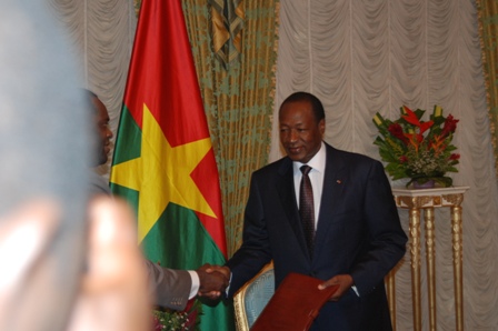 Le Président du Faso recevant le rapport des mains du Ministre d'État, Arsène Yé. ©Burkina 24