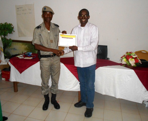 Le directeur d'Amnesty Burkina remettant un certificat de formateur à un  policier à l'issu de la formation. ©Amnesty Burkina