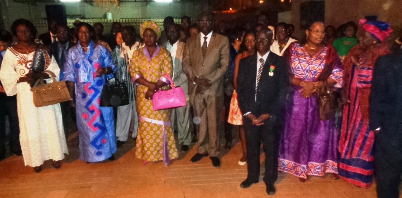 Dr Kanté Mamadou (costume noir et medaille), entouré de son épouse en robe violette, du ministre de la santé en costume kaki et des ses anciens collaborateurs