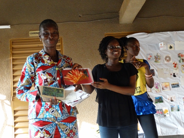 Noelie Kouarogo remettant de manière symbolique des cartes de solidarité à Catherine Ouédraogo. 