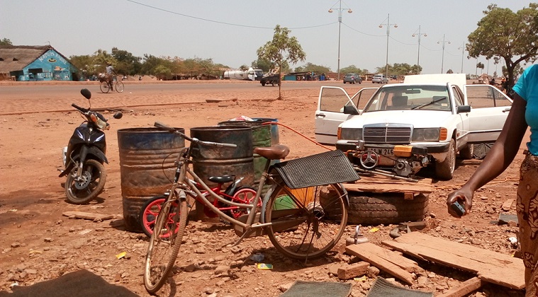 Ce laveur d'engins attend la précieuse manne pour satisfaire ses clients © Burkina24