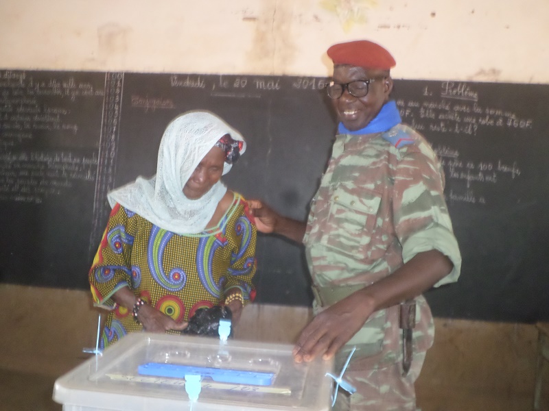 L’agent de sécurité aidant une électrice à voter
