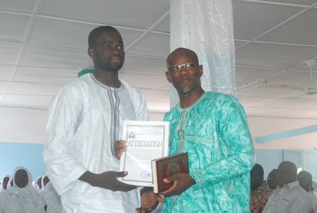 Le président du CERFI remettant son lot, composé d'une attestation et d'un Coran, à l'un des récipiendaires