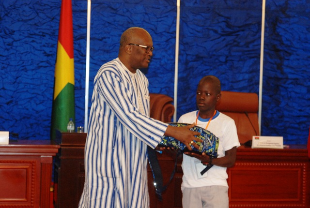 Le premier du CEP session de 2016 recevant son lot de récompense des mains du président du Faso